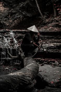 一位神秘的武士手持利剑，静坐在幽静的瀑布旁
