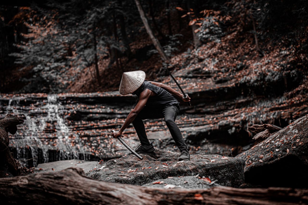 dramatic scene of a samurai wielding swords on a forest rock exuding d
