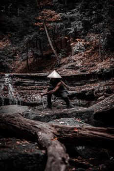 森林中，一个戴着亚洲锥形帽的武士蹲伏着，构成了一幅令人回味的图像