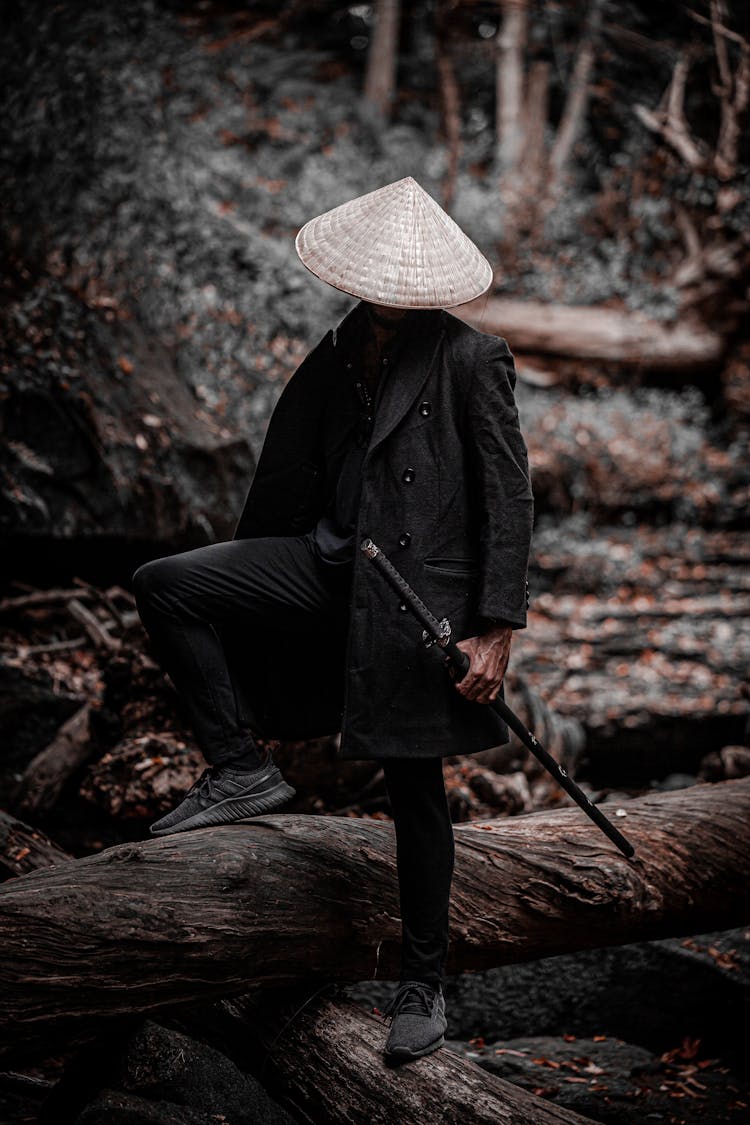 Person Stepping On Tree Trunk While Holding A Sword