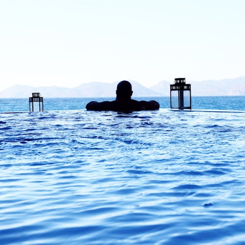 Man Floating on Pool in Front of Sea