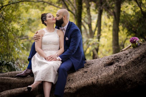 A Romantic Couple Sitting on a Tree Log