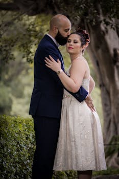 Bride and groom sharing an intimate moment in a lush garden setting.