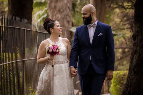 Free A joyous bride and groom walking outdoors, exuding love and affection on their wedding day. Stock Photo