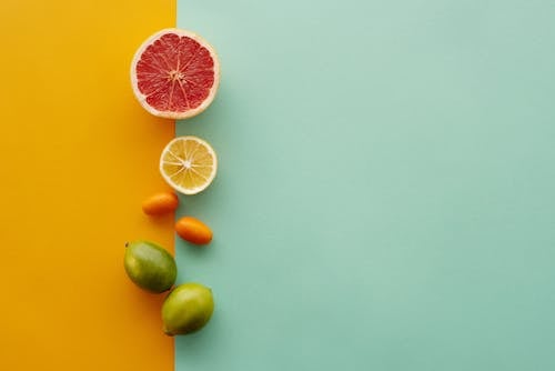 Citrus Fruits on Green and Yellow Surface