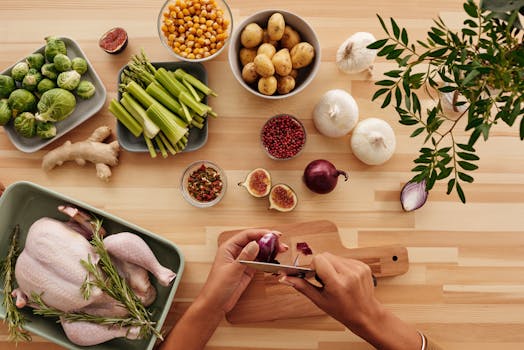 A vibrant flat lay of fresh ingredients with hands preparing vegetables for a healthy meal.