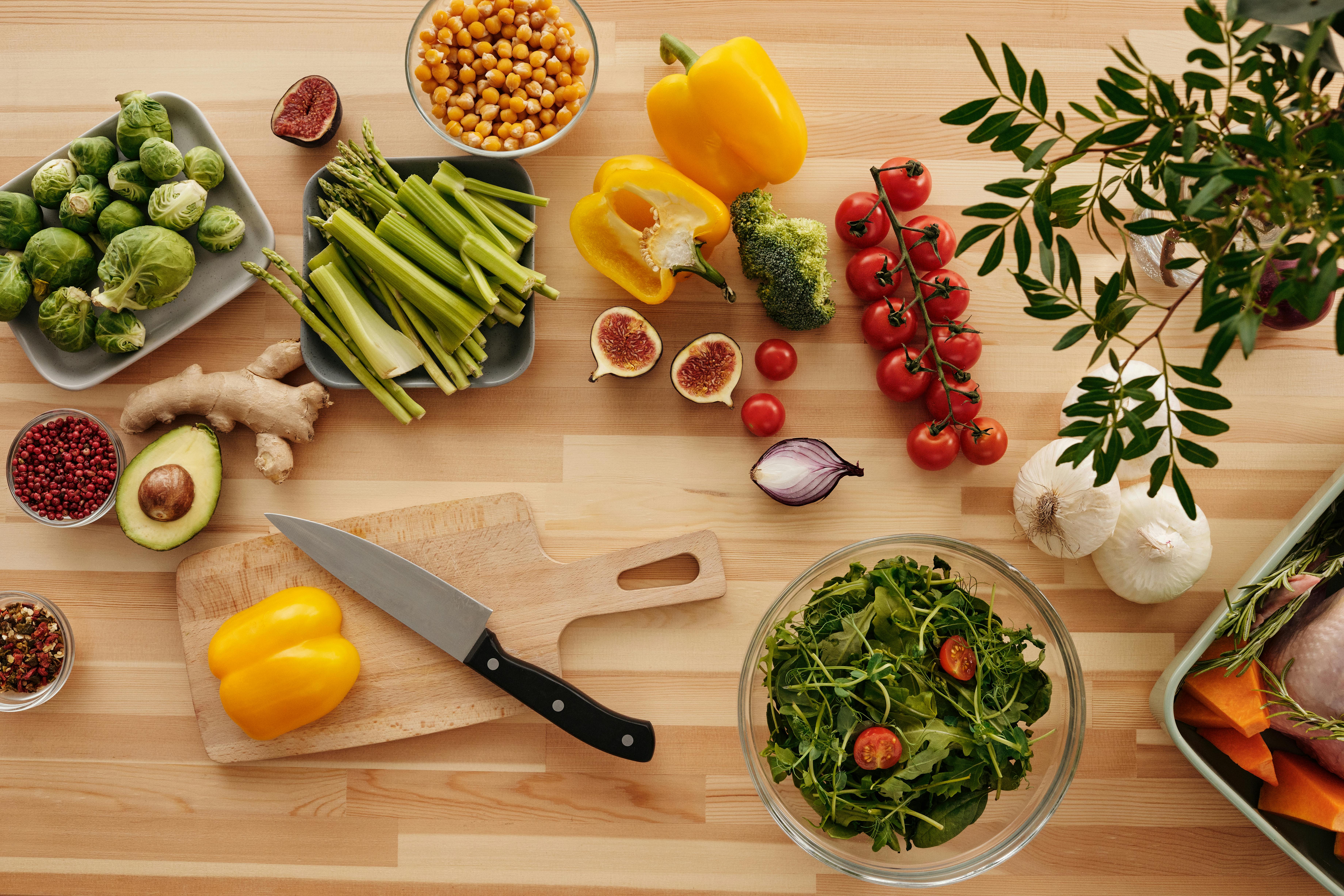 Free Top view of fresh vegetables and ingredients on a wooden table, perfect for healthy cooking inspiration. Stock Photo