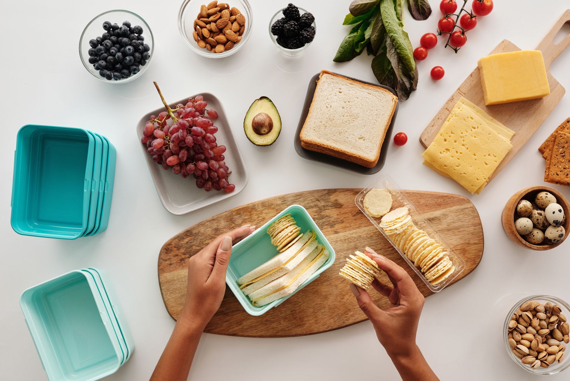 健康飲食遠離焦慮:食物推薦緩解日常煩惱 Top view of preparing a healthy lunch with fruits, cheese, and crackers, showcasing fresh ingredients and a vibrant lifestyle.