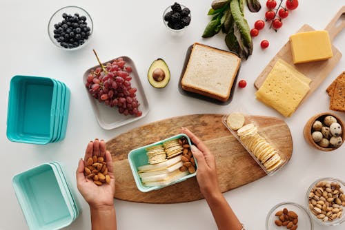 Free A Person Holding Turquoise Container with Breads and Nuts Stock Photo