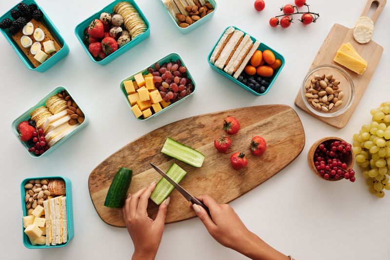 small lunch board with cheese, crackers, olives, and grapes