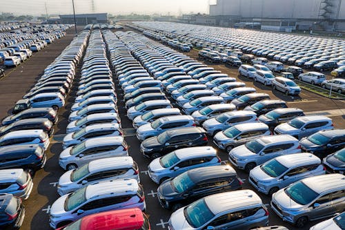 Rows of expensive modern cars on asphalt parking of manufacture