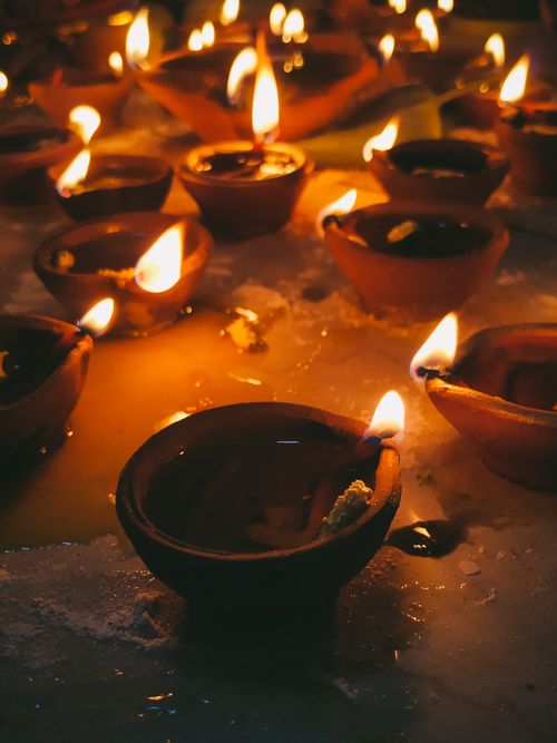 Free Warm glow of burning oil lamps in clay pots during Diwali, offering a traditional festive ambiance. Stock Photo