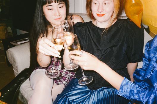 三名妇女在室内派对上举杯庆祝，互相敬酒