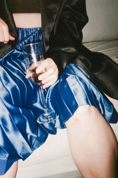 特写一位身着优雅蓝色服装、手持香槟杯的人物，非常适合生活方式主题