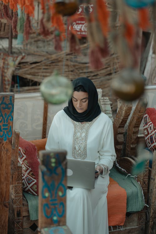 A Woman in a Hijab Using a Laptop