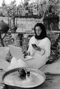 Woman in White Long Sleeve Shirt Sitting on Woven Chair