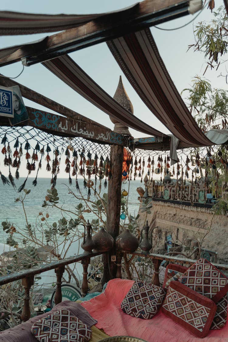 Pillows And Blankets On A Wooden Balcony With A View Of The Ocean