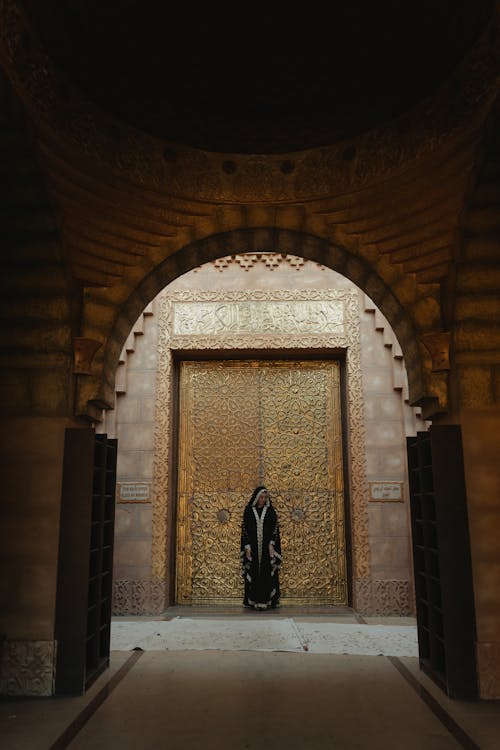 A Woman in Black Abaya Standing at the Doorway