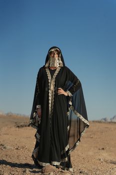 一位身着传统服装、站在沙漠中的女人的肖像
