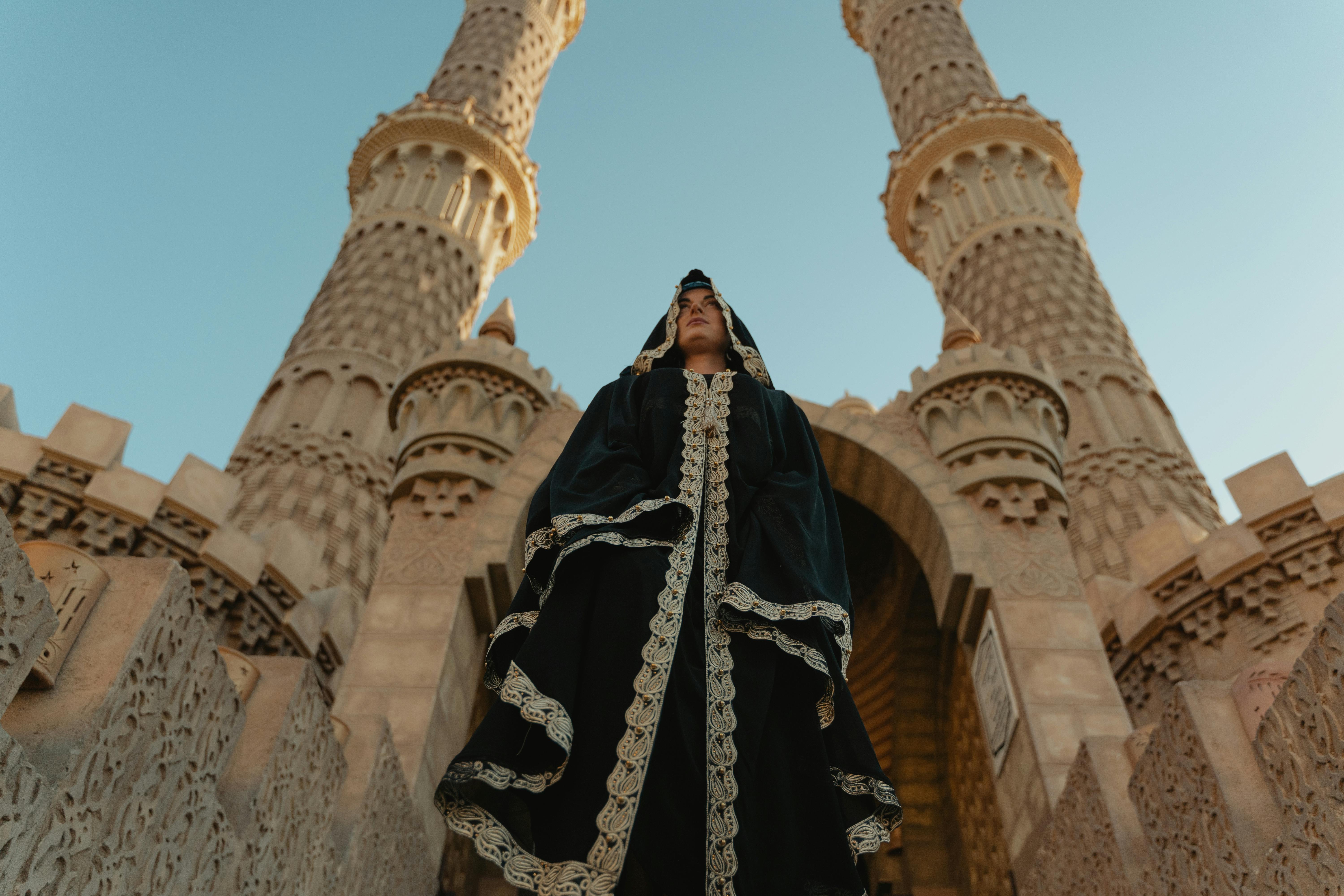 woman in black dress standing beside minarets