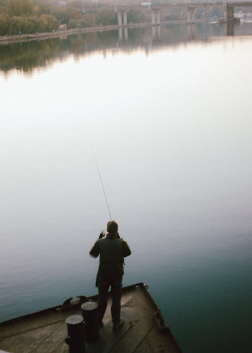 Unrecognizable fisher standing on pier