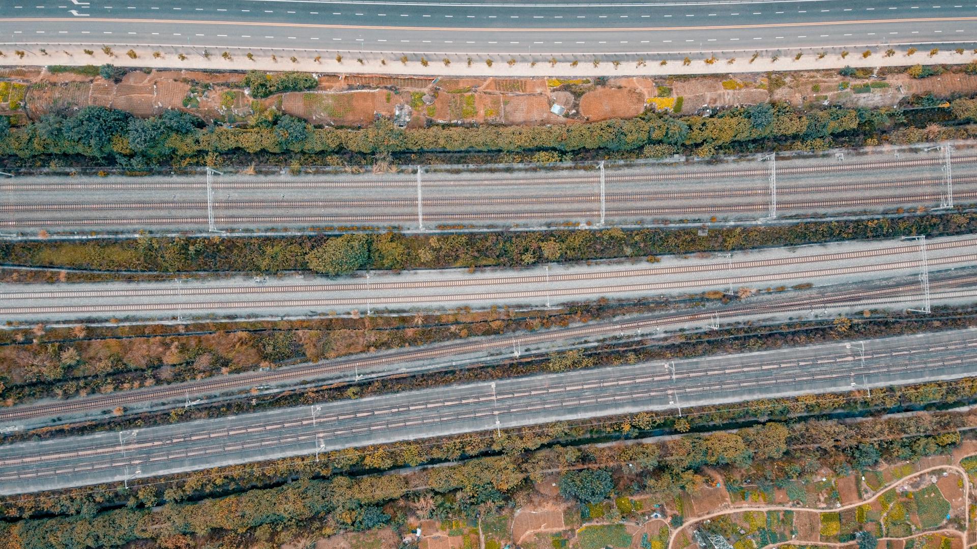 Aerial photo showcasing intersecting railway tracks and roads, highlighting transportation infrastructure.