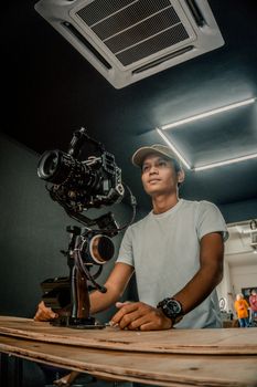 Portrait of a man operating a gimbal camera in a professional studio setting.
