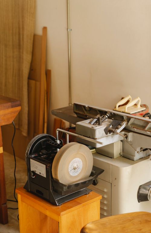 Bench grinder with sharp metal wheel in a workshop