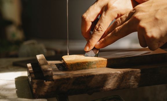 Crop artisan sharpening chisel in workshop
