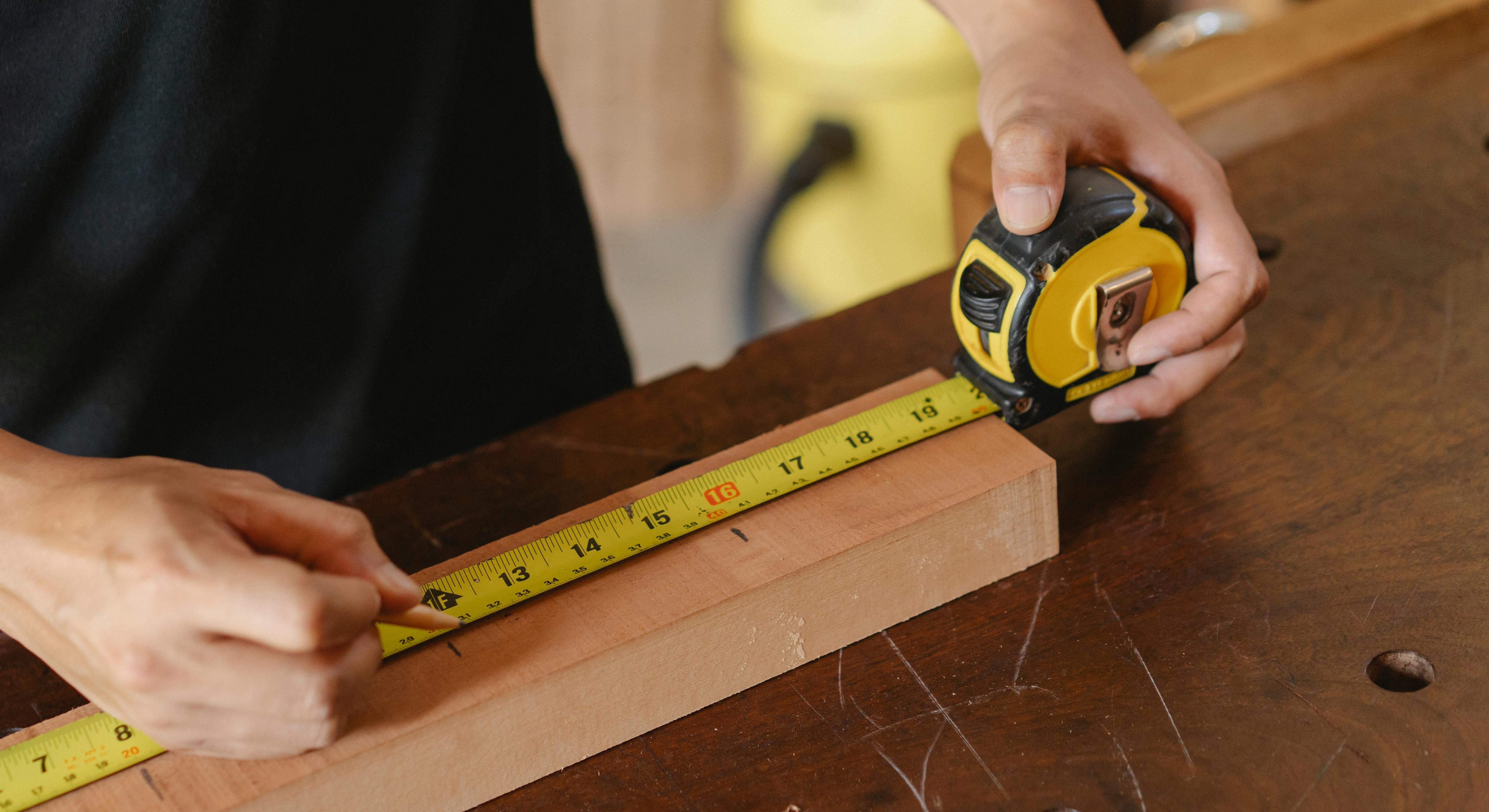 crop man using ruler in workshop