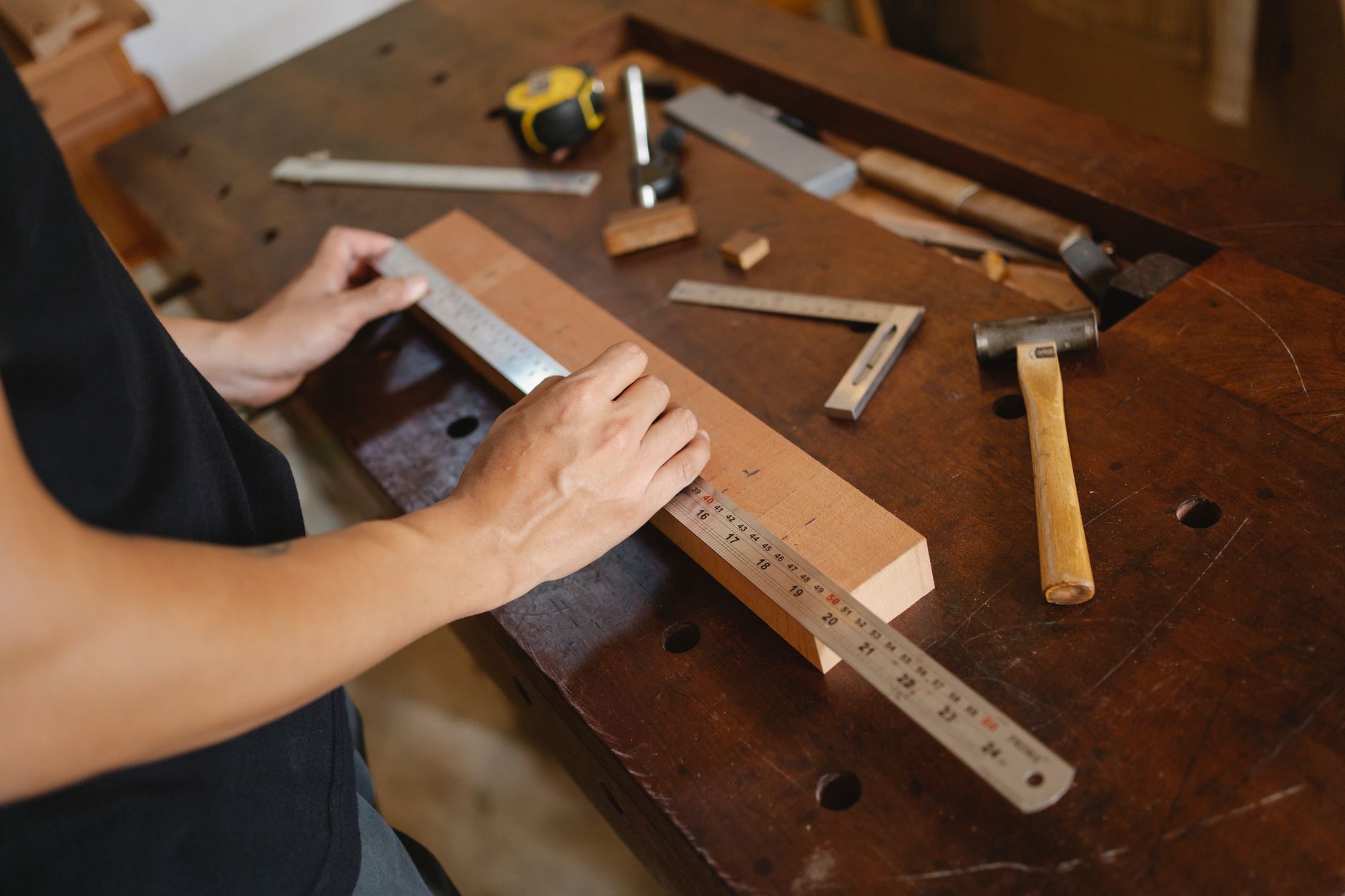 Man measuring wooden plank with ruler · Free Stock Photo