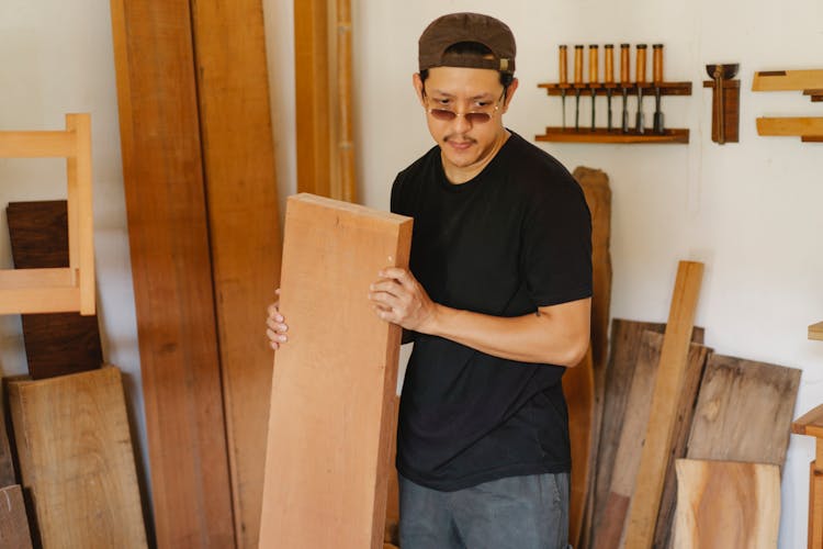 Asian Man Carrying Wooden Plank And Thinking