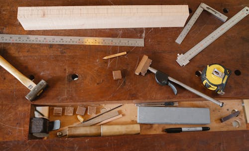 Top view of various equipment for joinery and measuring placed on timber table