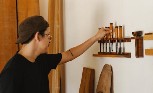 Serious man in eyeglasses choosing instruments for joinery