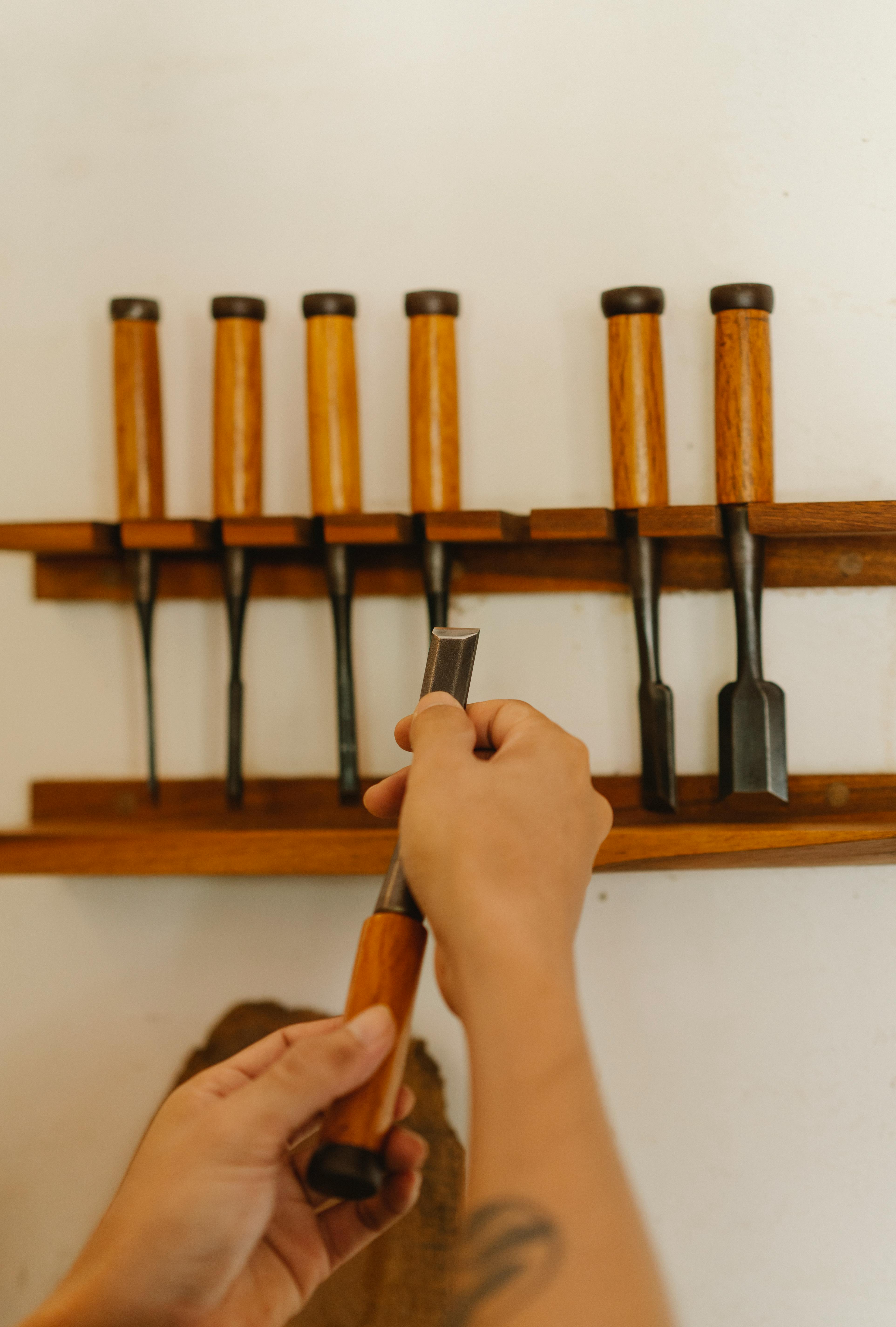 person choosing chisels for wood carving