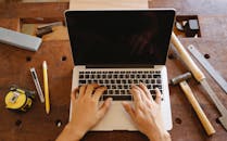 Crop man using laptop in workshop