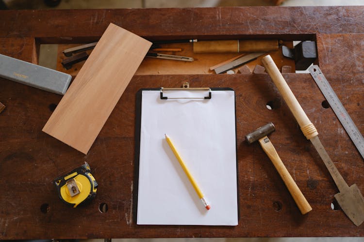 Yellow Pencil On White Paper And Carpentry Tools