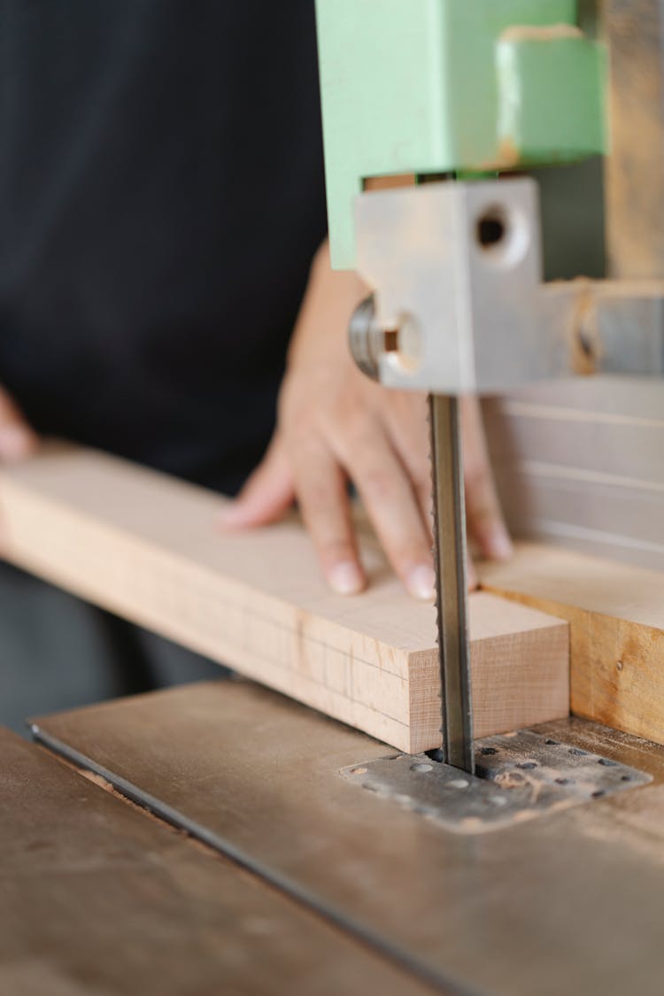 Crop Woodworker Cutting Wooden Plank With Band Saw