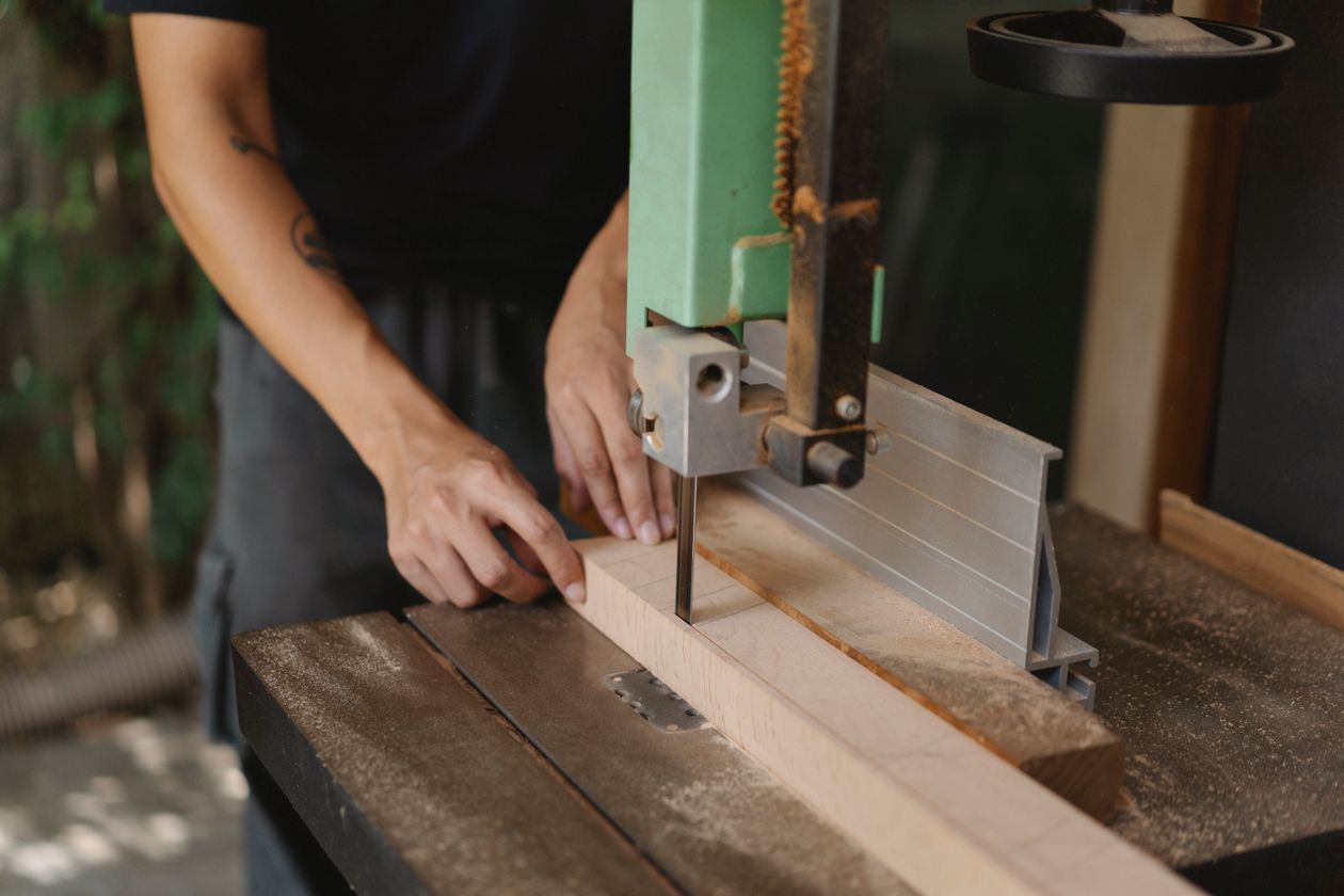 Woodworker cutting timber with a band saw