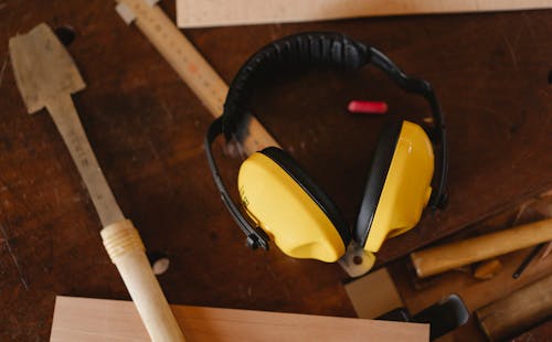 Protective headphones near carpentry tools on workbench