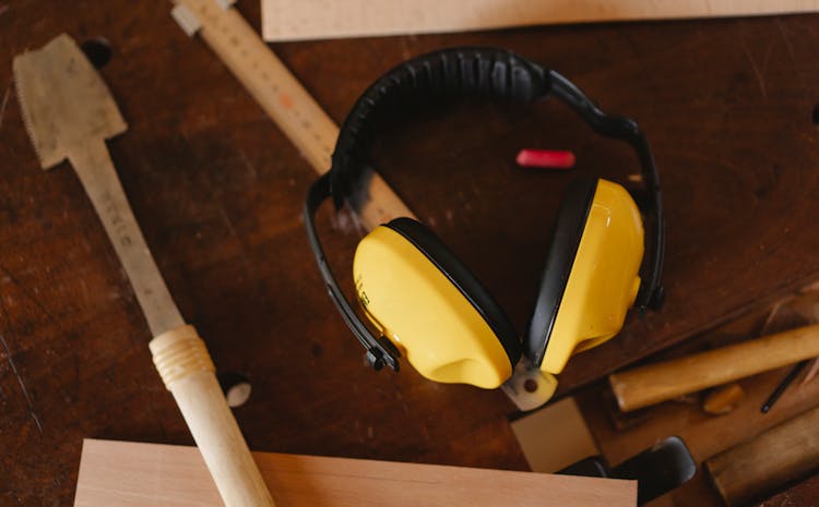 Protective Headphones Near Carpentry Tools On Workbench