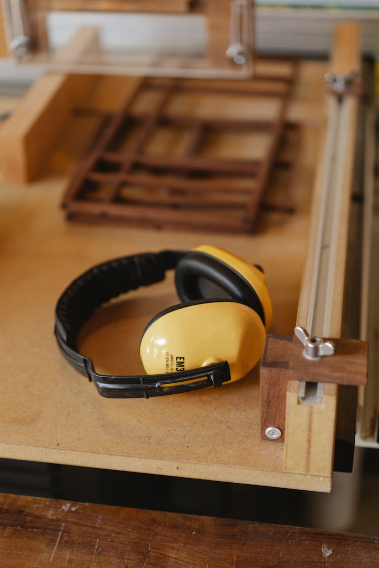 Protective Headphones For Woodwork On Wooden Table