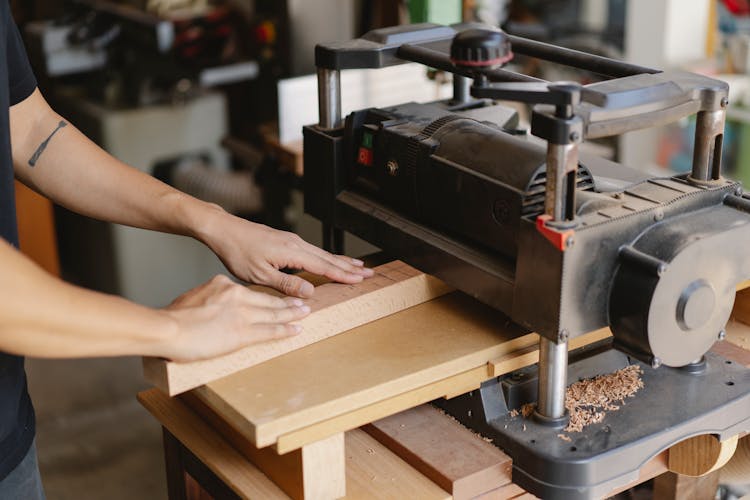 Crop Artisan Flattening Lumber On Planer In Workroom