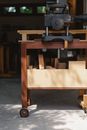 Professional electric machine for carpentry with wooden planks in workroom on blurred background