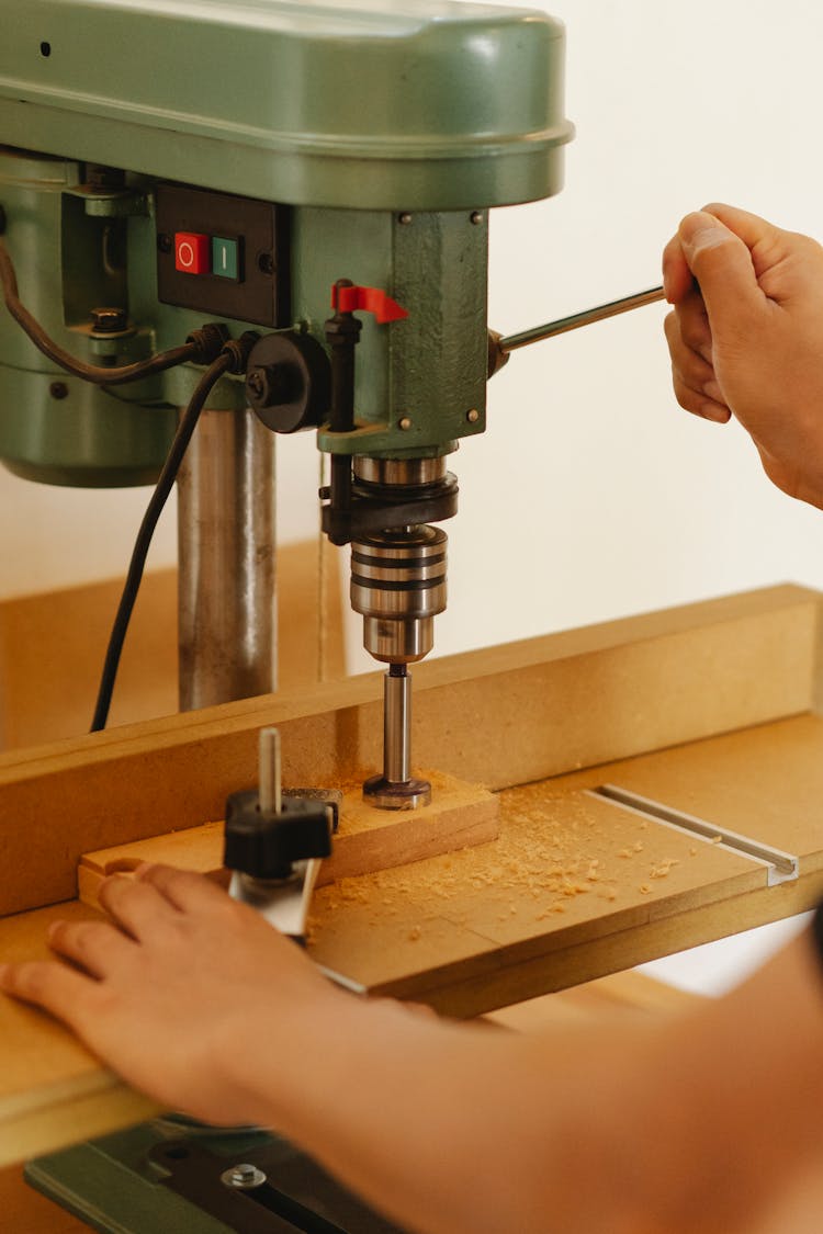 Faceless Artisan Drilling Wooden Block With Drill Press In Workshop