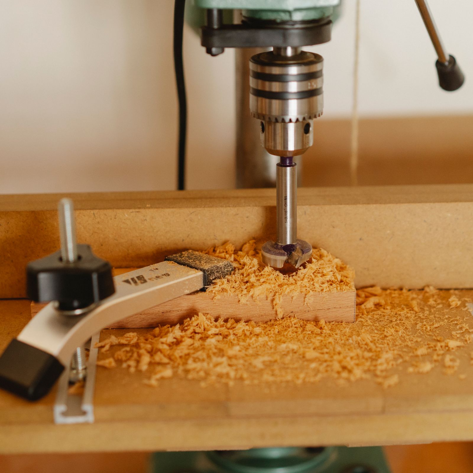 Foto de contexto de un taladro de banco trabajando madera; no muestra el modelo TAPI-8