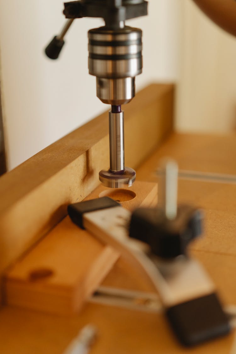 Drill Press And Lumber With Holes In Workshop