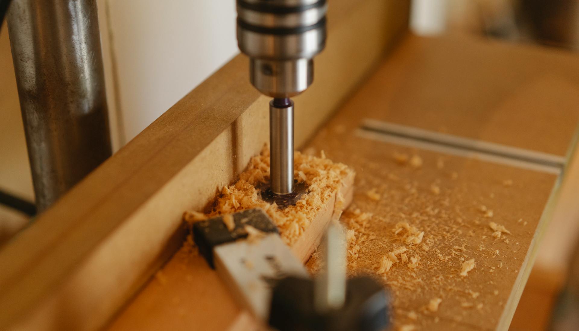 Boring machine drilling hole in wooden plank