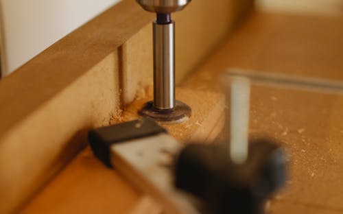 Drill press on wooden surface in workshop