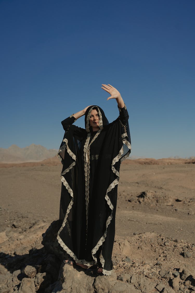 Woman In Black Abaya Standing On Desert